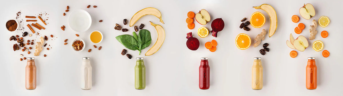 kuvings cold pressed immune booster with fruit nuts and juice bottles arranged.