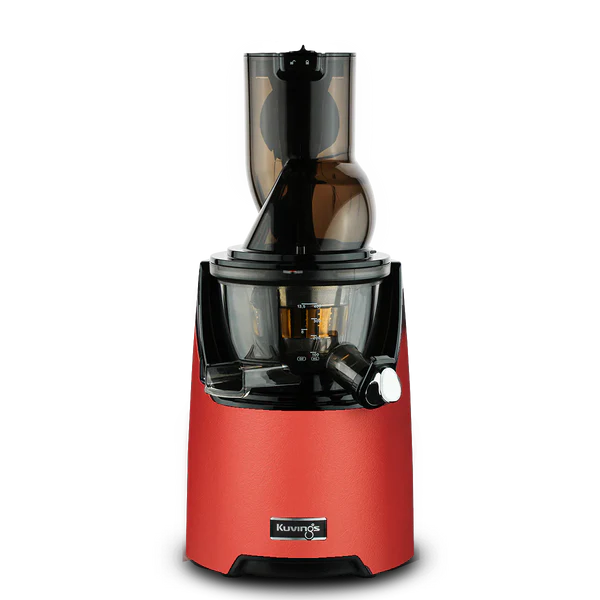 Three-quarter studio product shot of a Kuvings EVO820 whole slow juicer featuring a textured matt red motor base with a black Kuvings logo badge, assembled with its dark translucent juicing drum and wide-mouth O-shape feeding chute against a transparent checkered background.