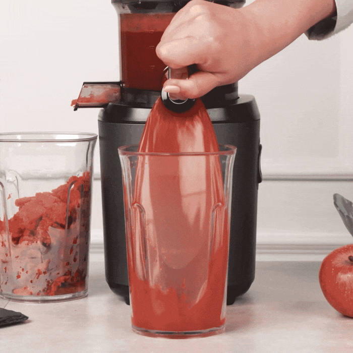 kuvings black auto 6 from front view puring out red juice in gif format